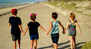 girl in blue denim shorts and green tank top walking on the street during daytime