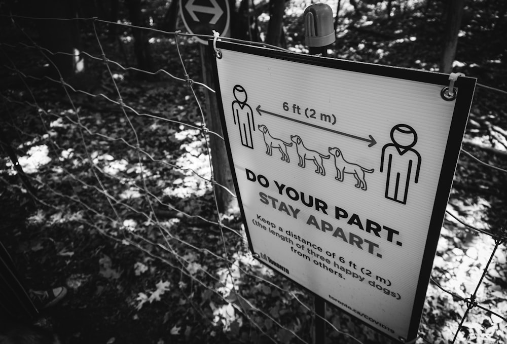 a do your part stay apart sign next to a fence