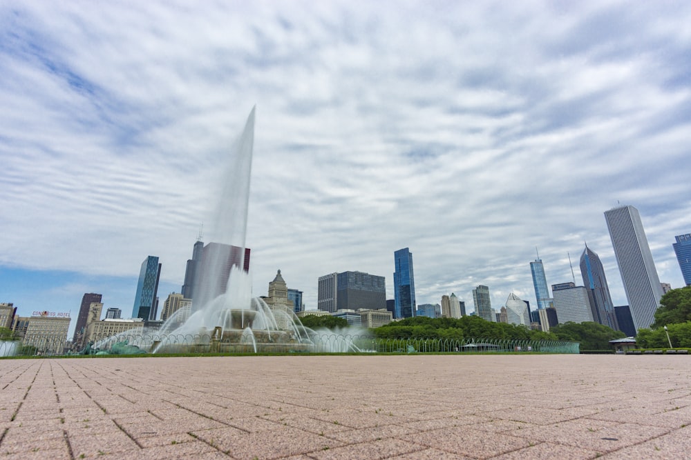 green grass field near city buildings during daytime