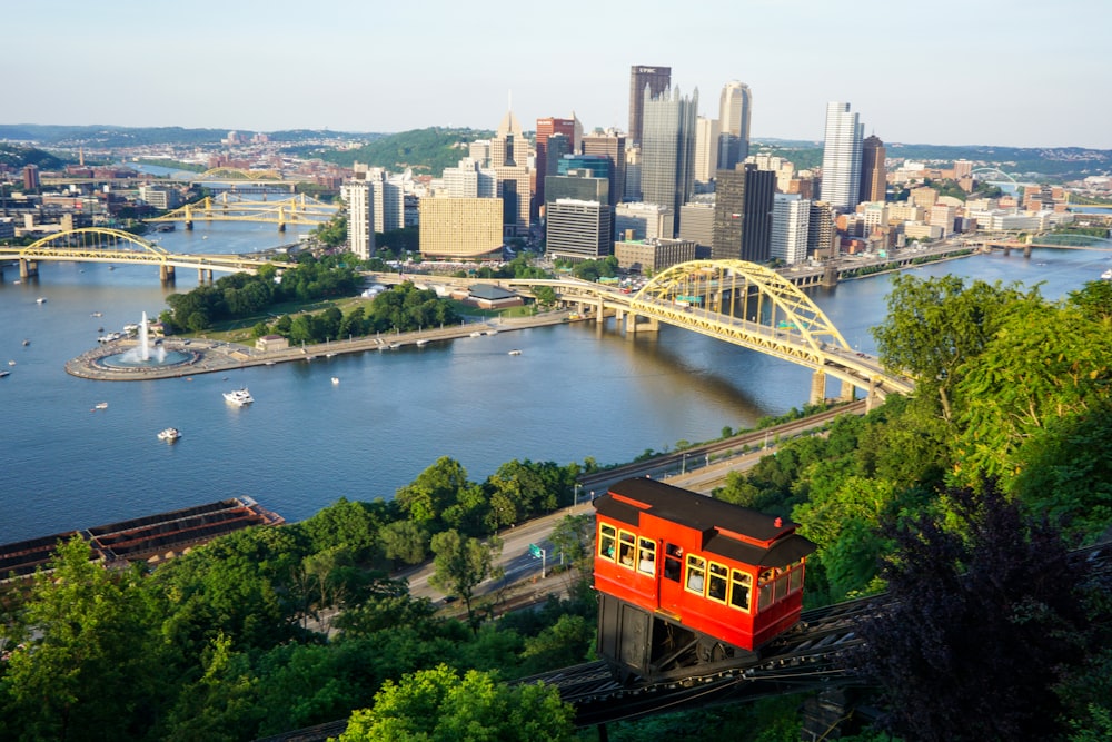 orange train on bridge over river during daytime