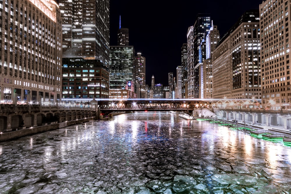 body of water between high rise buildings during nighttime