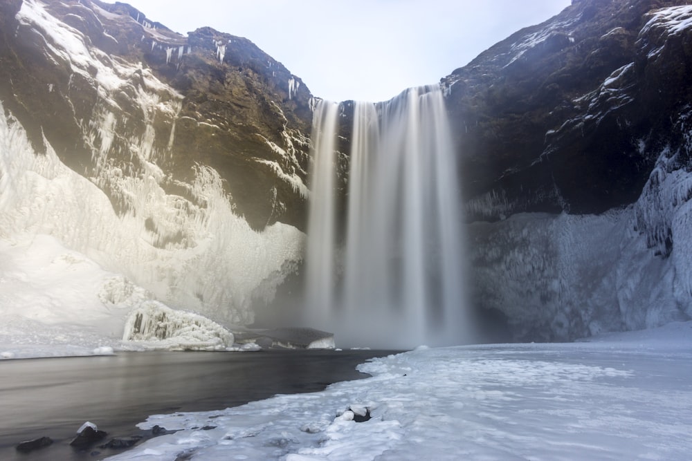 waterfalls on snow covered ground during daytime