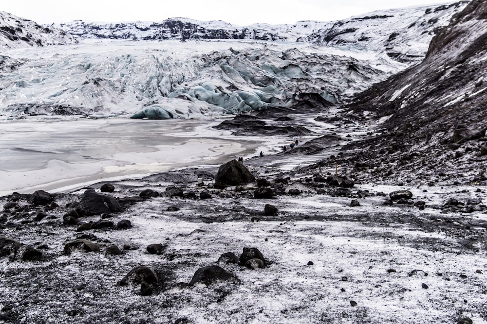 rocky shore with snow covered mountain in distance