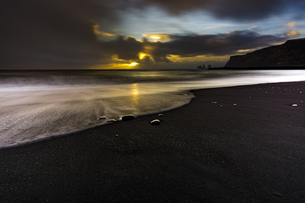 sea waves crashing on shore during sunset