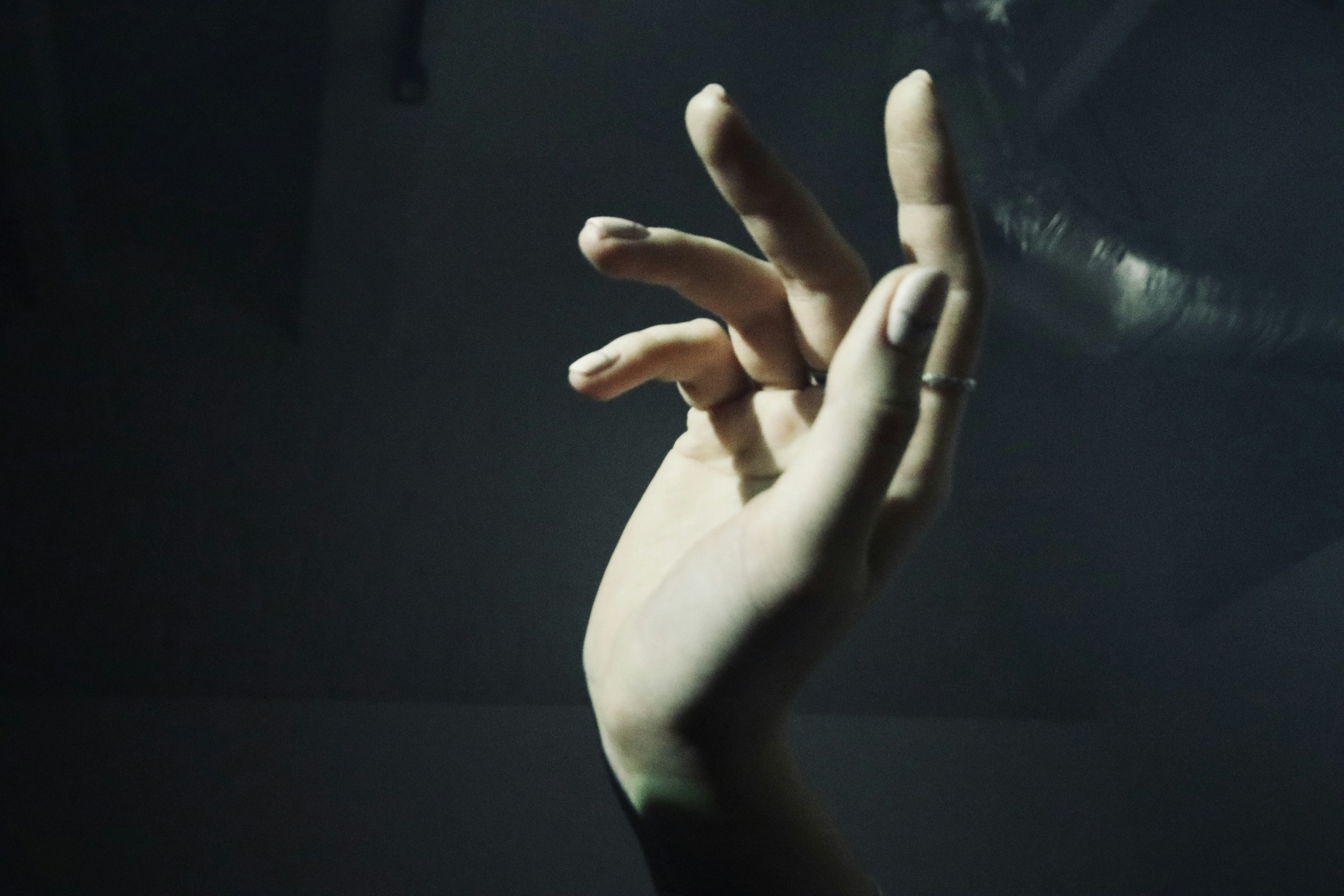 persons left hand doing peace sign