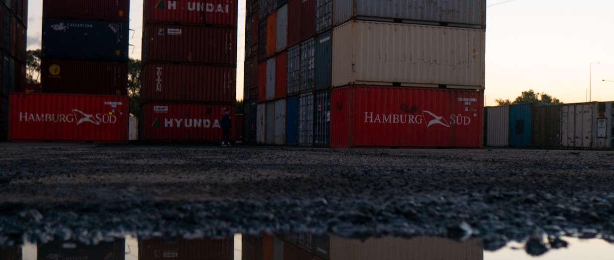 red and blue cargo containers on brown wooden dock during daytime