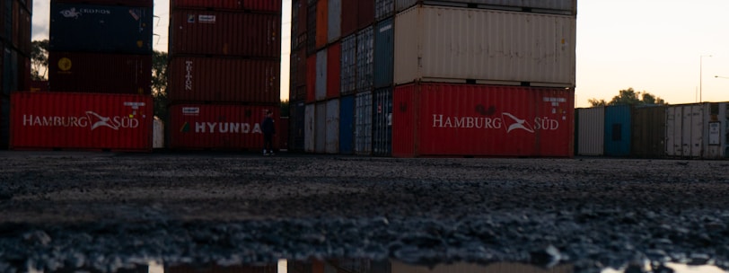 red and blue cargo containers on brown wooden dock during daytime