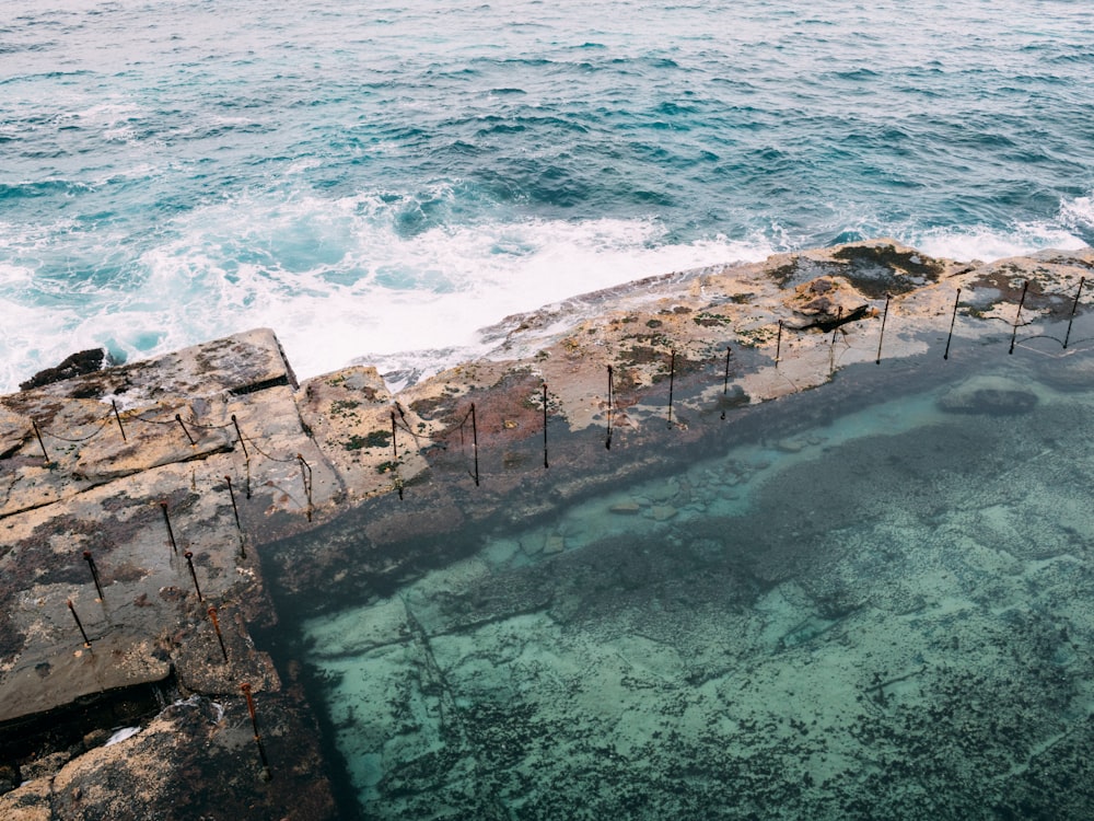 brown rock formation on body of water during daytime