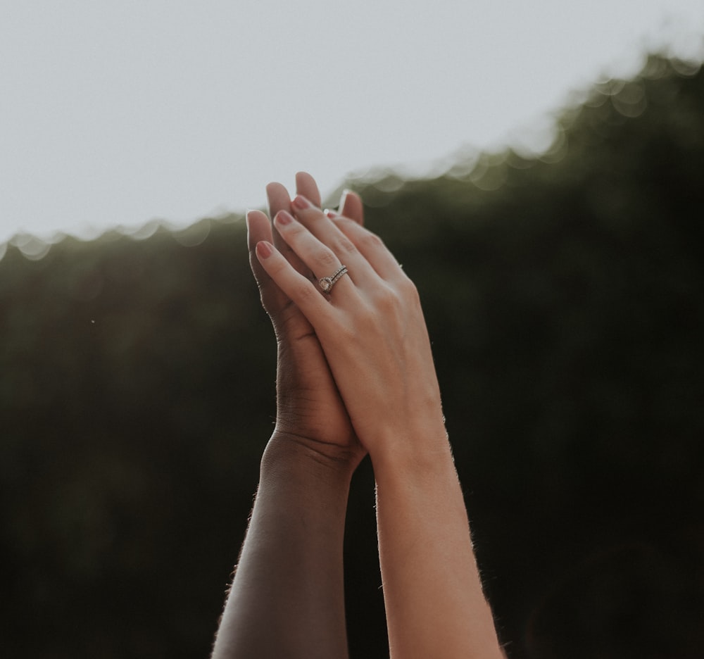 persons hand on green grass field during daytime