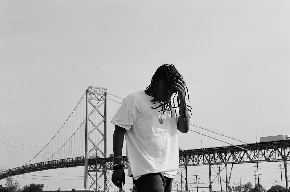 woman in white shirt standing on bridge