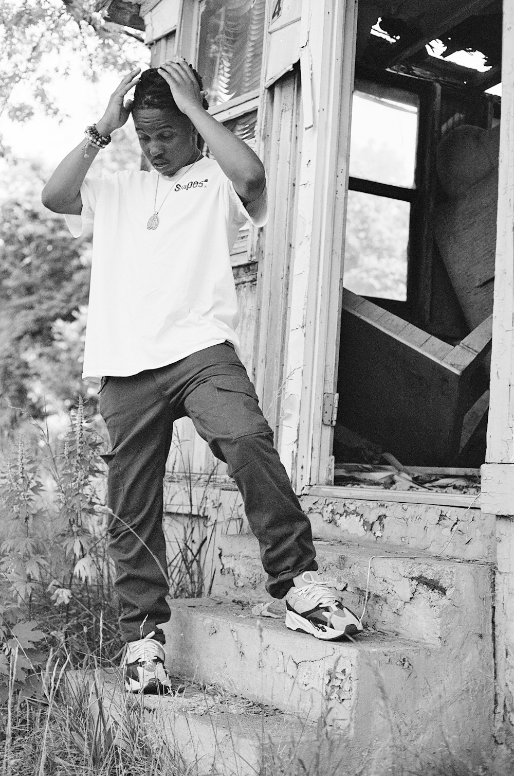 man in white shirt and black pants standing on window