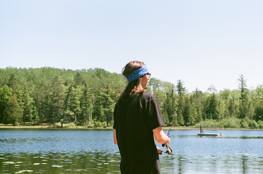 woman in black dress standing on lake during daytime