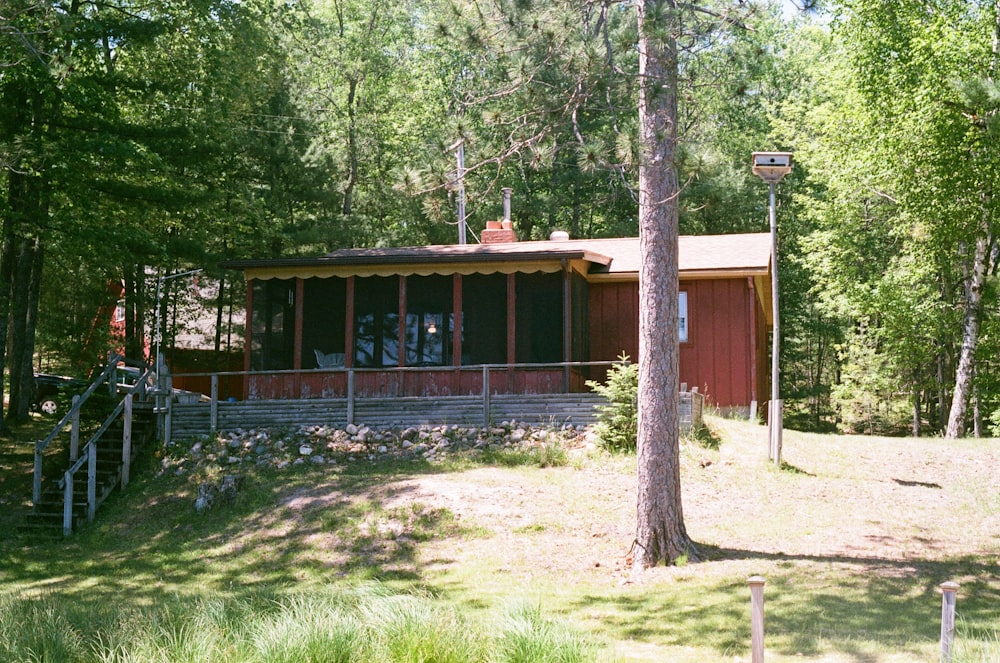 brown wooden house surrounded by green trees during daytime