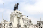man riding horse statue near white concrete building during daytime
