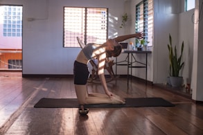 woman in black shorts and white tank top doing yoga