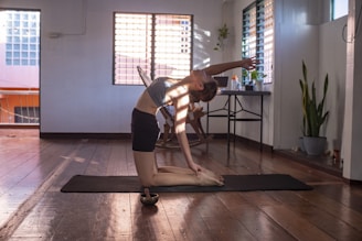 woman in black shorts and white tank top doing yoga