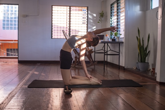 woman in black shorts and white tank top doing yoga