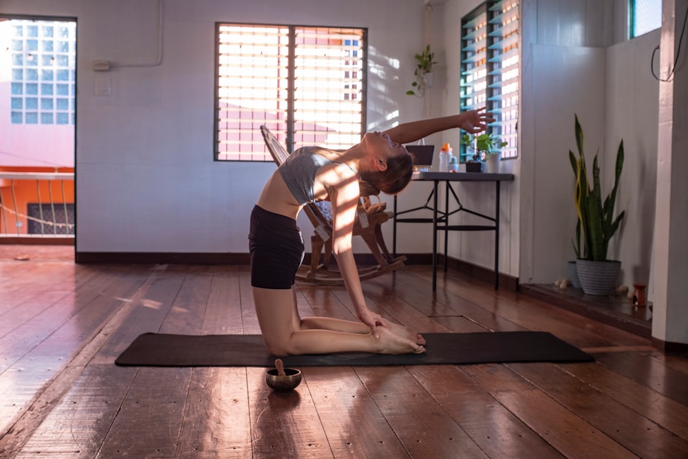 woman in black shorts and white tank top doing yoga
