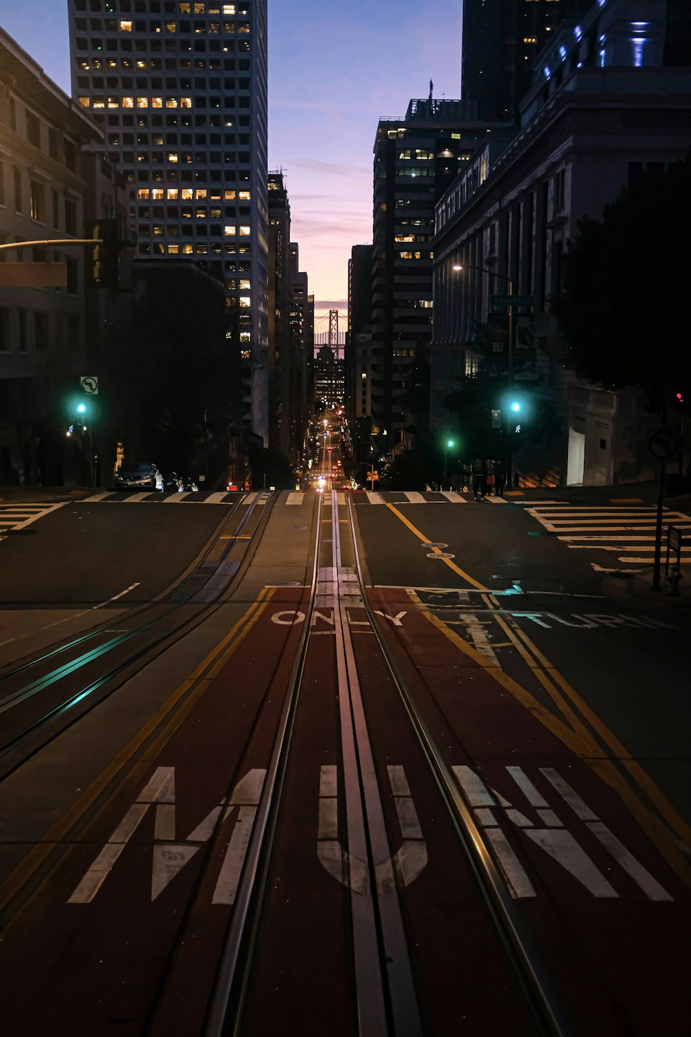 cars on road near high rise buildings during night time