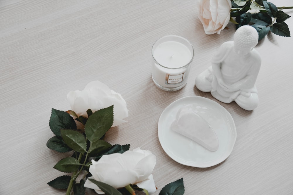 white ceramic round plate beside white ceramic teacup on brown wooden table