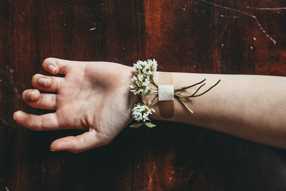 fiori bianchi sulla mano delle persone