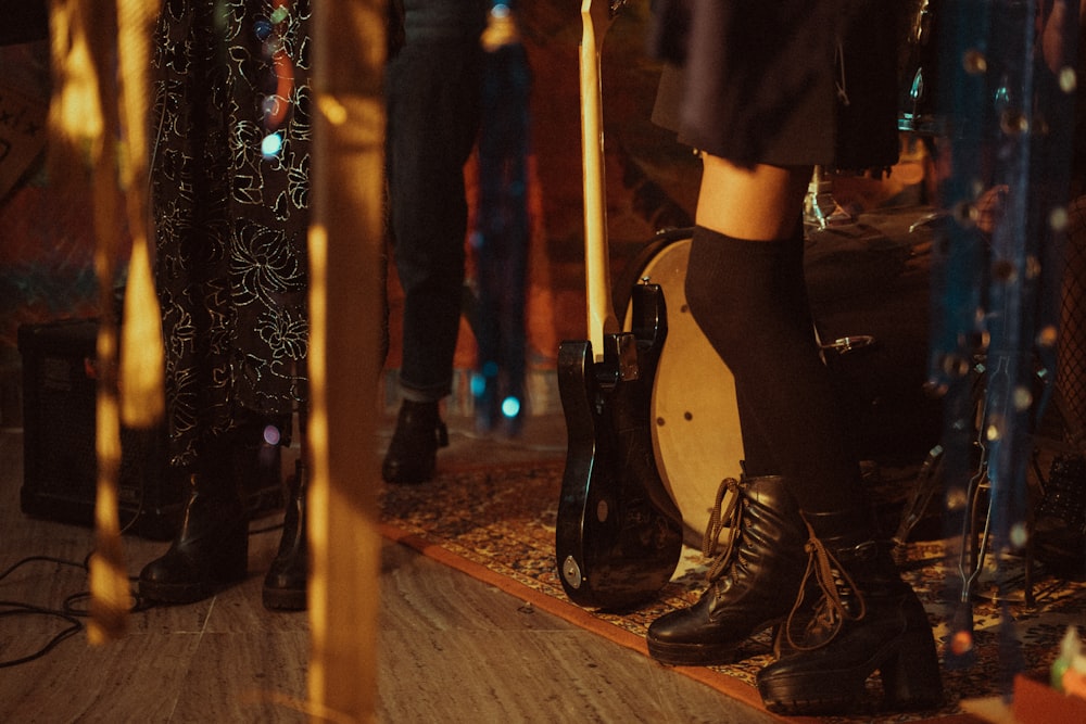 woman in black leather boots standing on brown wooden floor