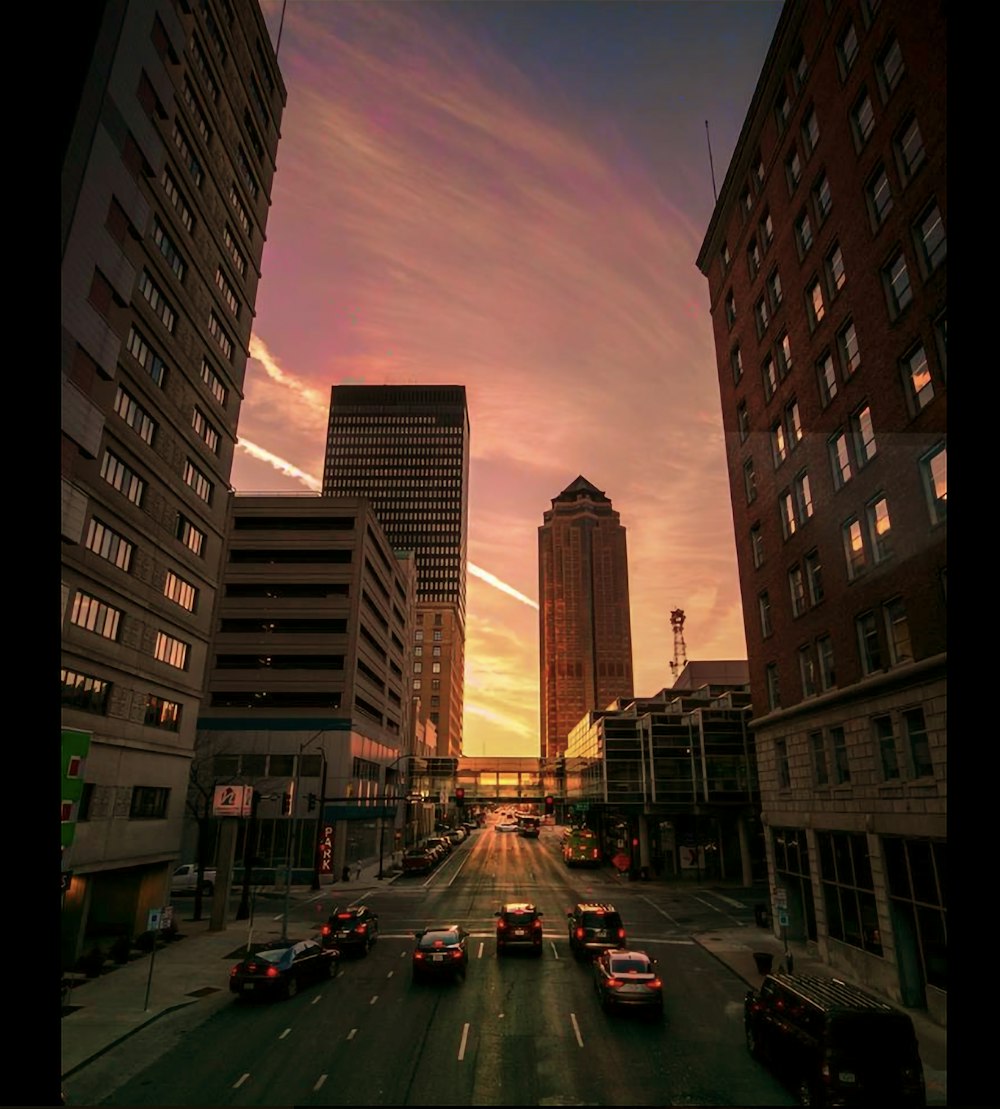 cars on road between high rise buildings during night time