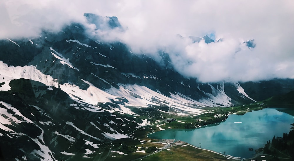 Montañas cubiertas de nieve bajo nubes blancas durante el día