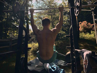 Philippe doing bodyweight exercises in his backyard, sweat on his brow.