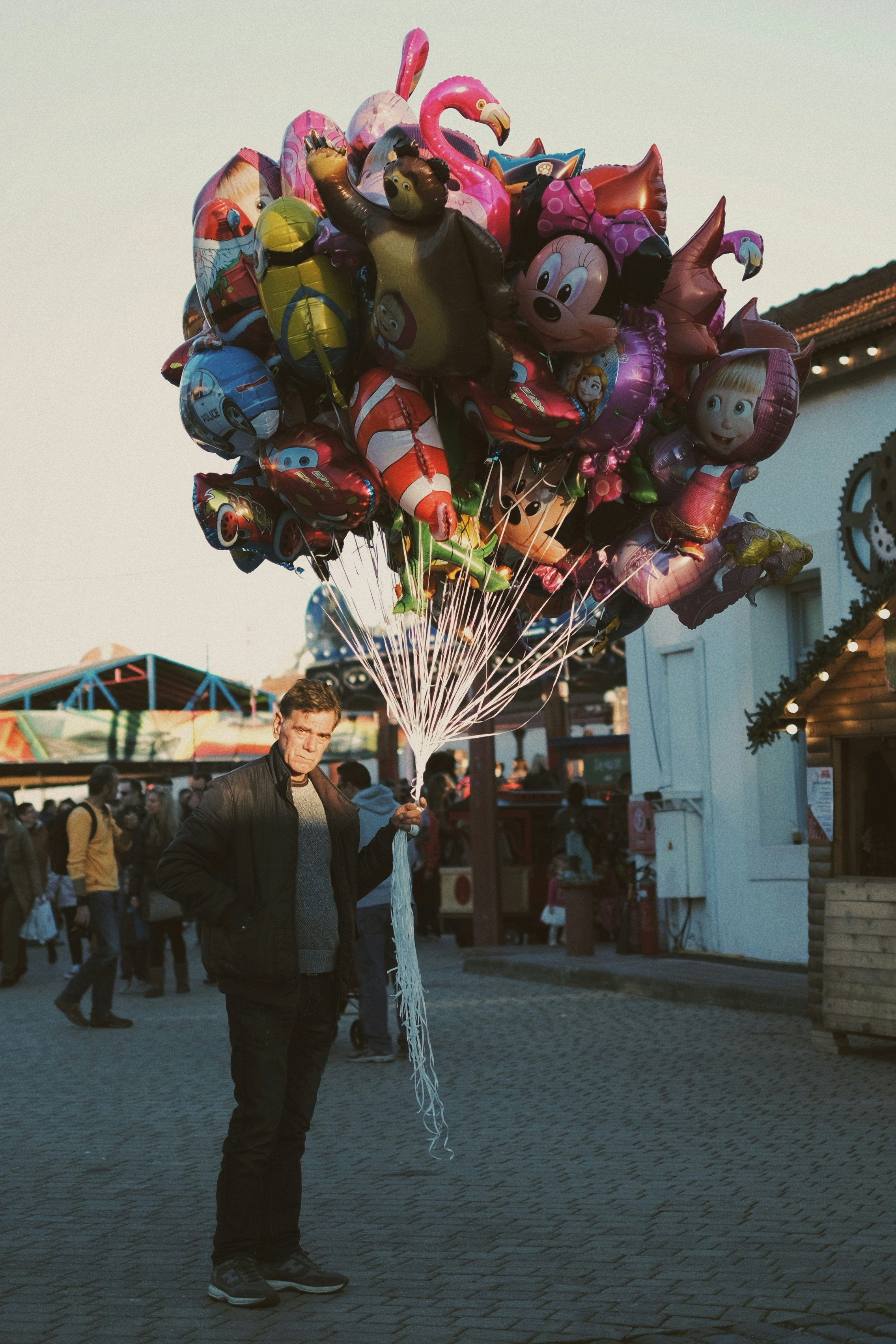 homme en veste noire tenant des ballons