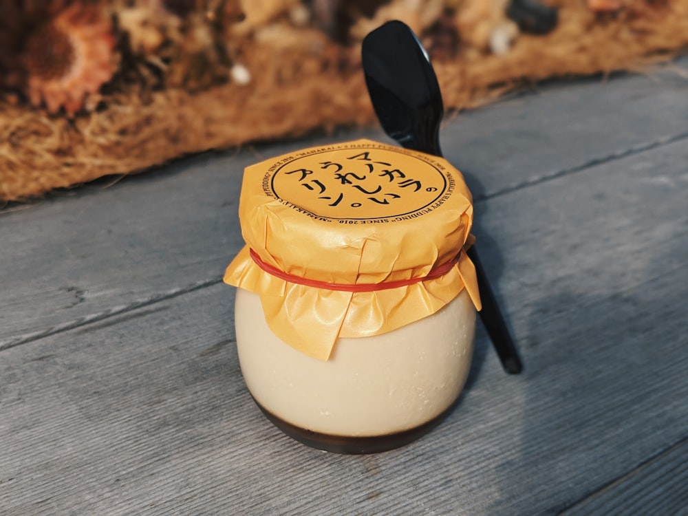 white and yellow ceramic container on gray wooden table