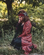 A woman praying with children in a peaceful outdoor setting.