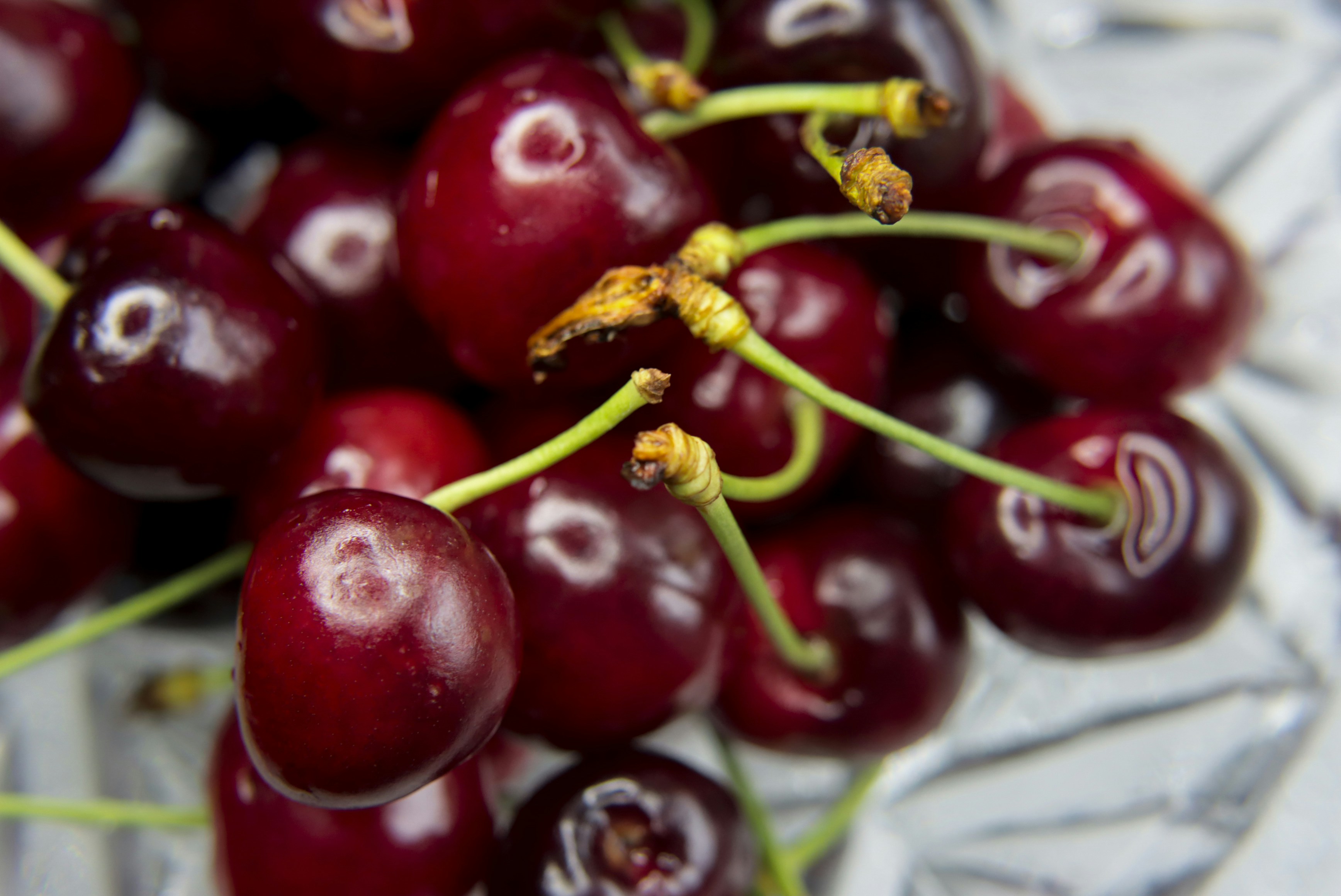 Golden-red Rainier cherries with stems on a white background in natural light