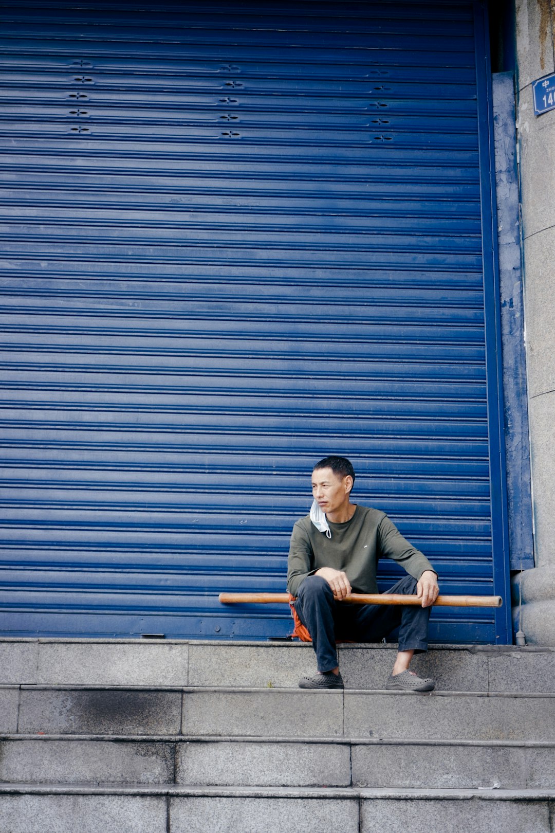 man in brown jacket sitting on brown wooden bench