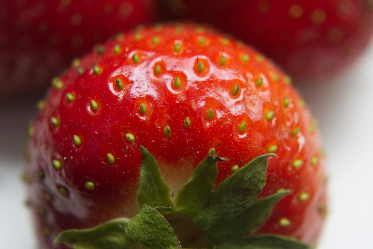 花のついた、真っ赤に熟したいちごの実のアップ