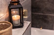 Warm ivory and gold bath salts and candles glowing softly in a cozy bathroom setting.