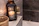 A cozy living room corner bathed in soft candlelight with elegant neutral-toned decor.