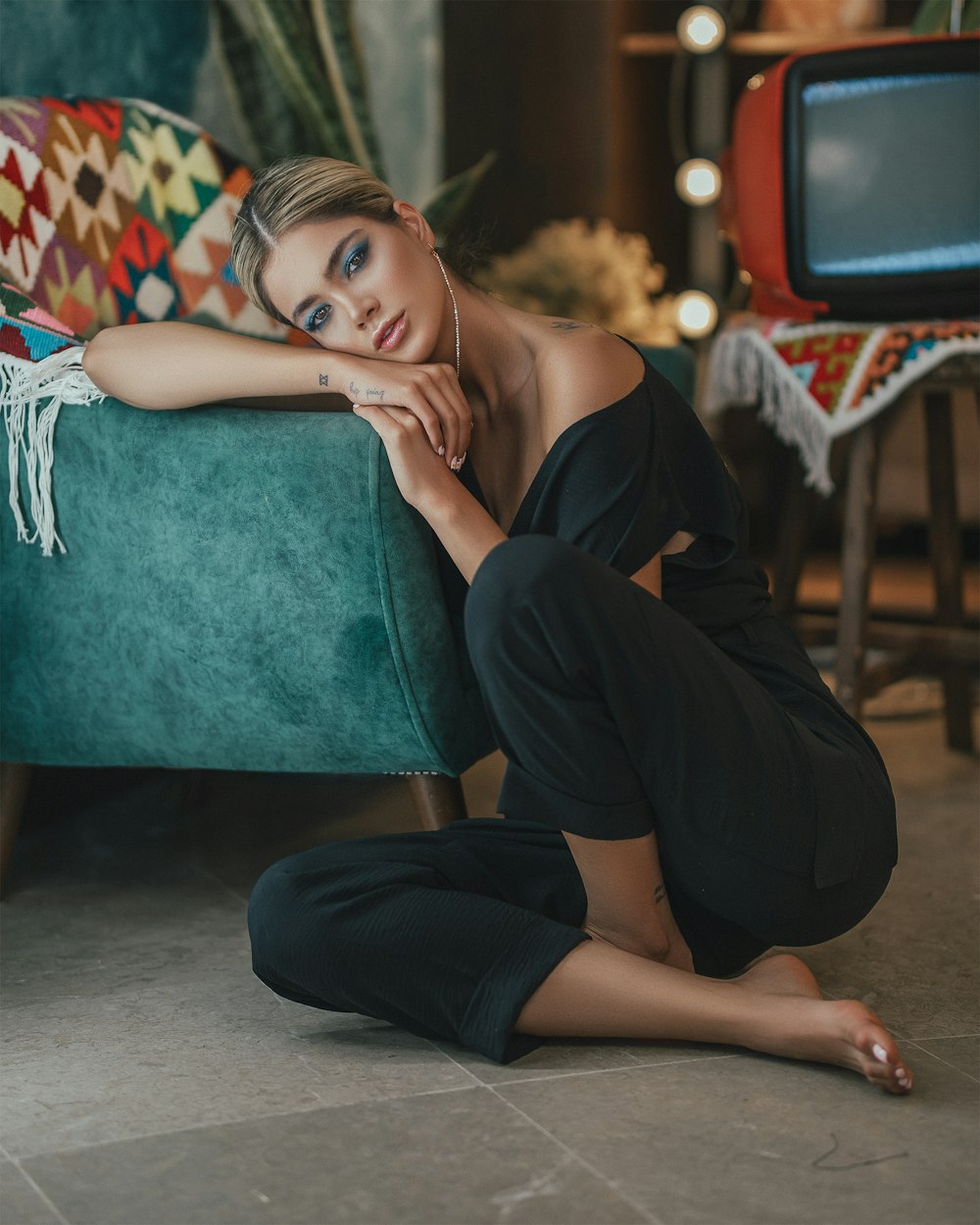 woman in black shirt and black pants sitting on blue chair