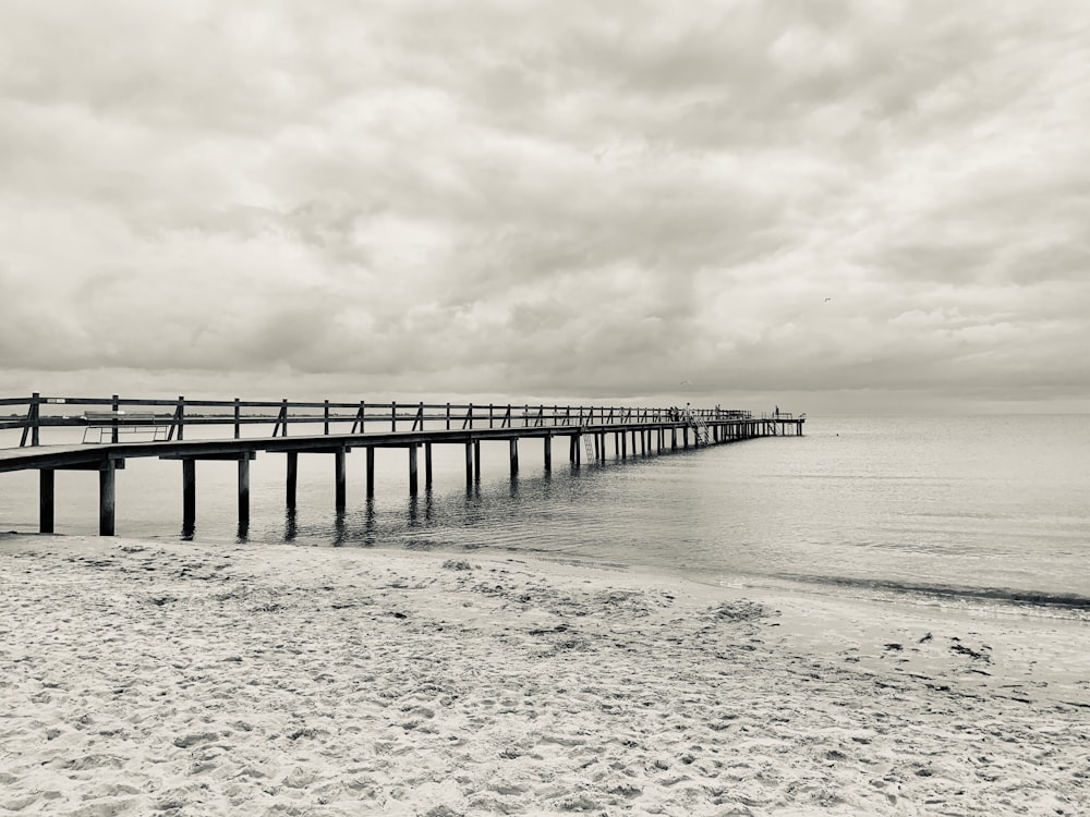 gray wooden dock on sea under gray clouds