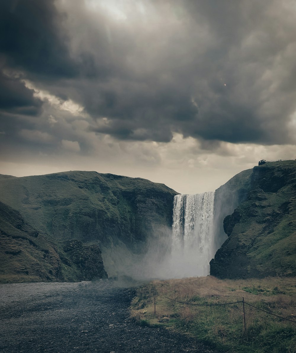 waterfalls under cloudy sky during daytime