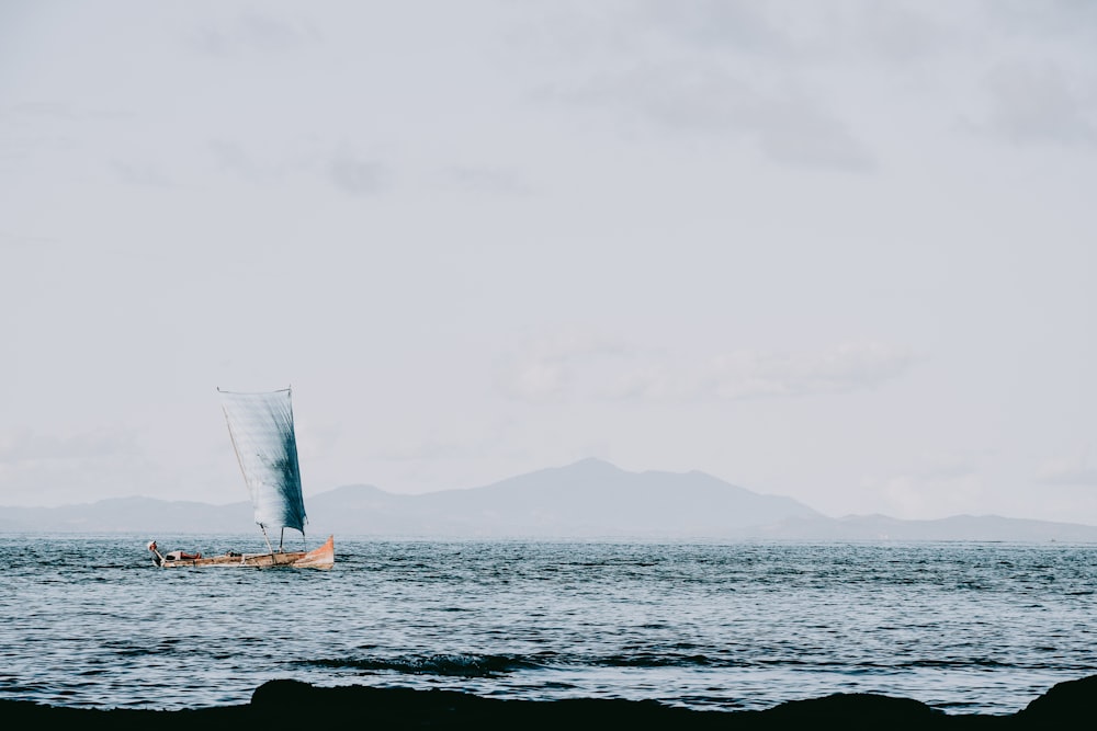 white sail boat on sea during daytime