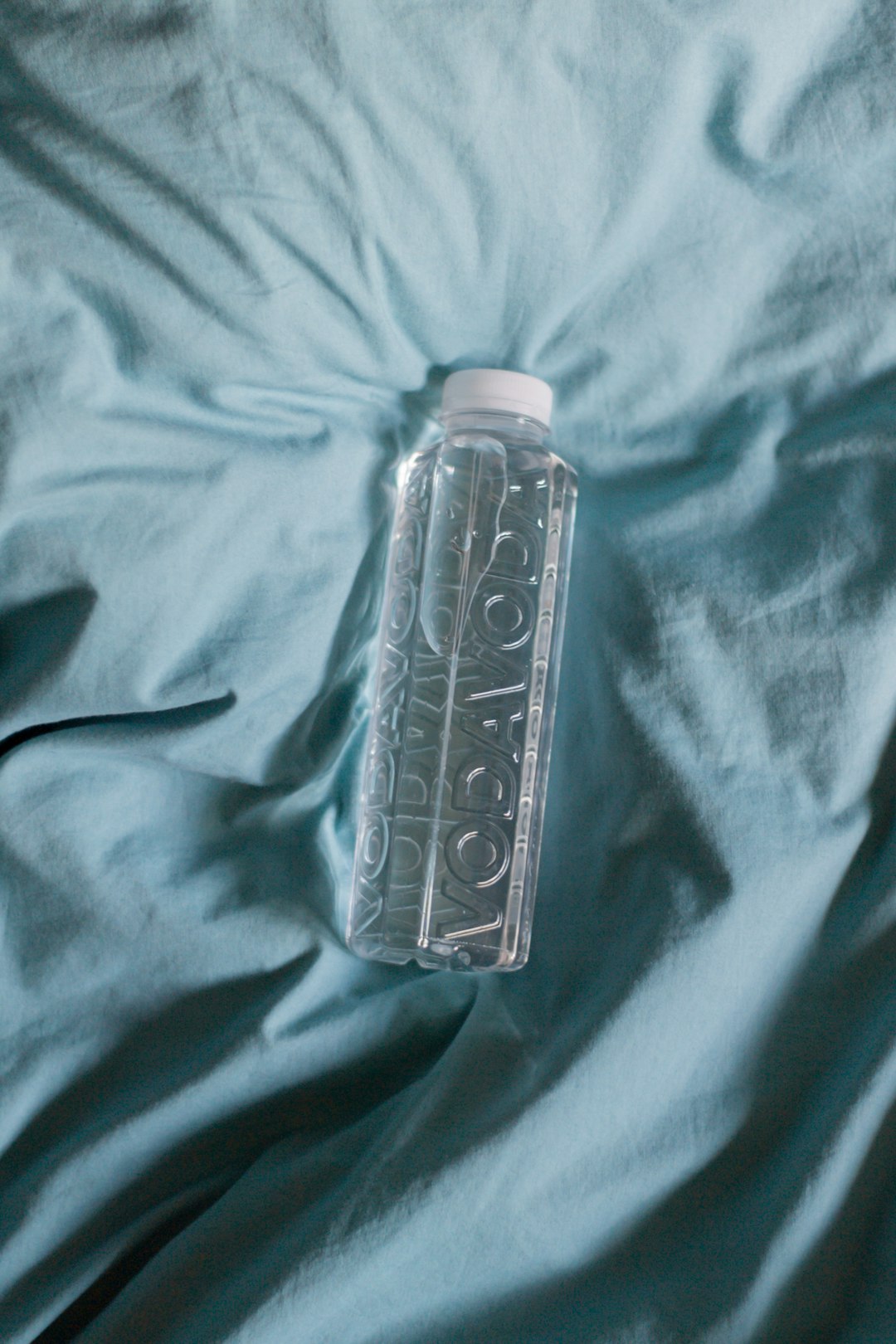 clear plastic bottle on blue textile