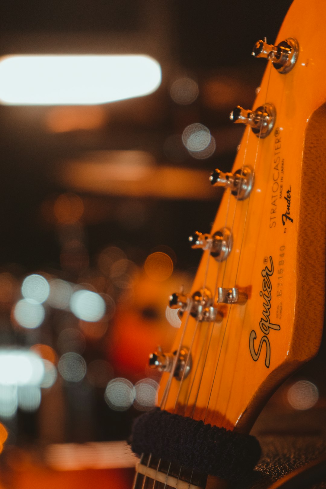orange guitar head stock in close up photography