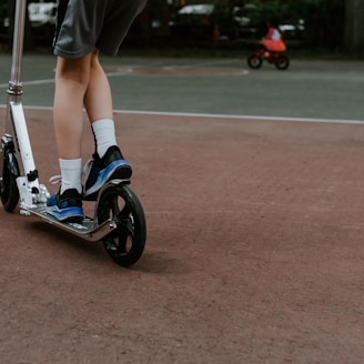 person in black and white nike sneakers riding blue and white skateboard during daytime