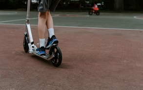 person in black and white nike sneakers riding blue and white skateboard during daytime