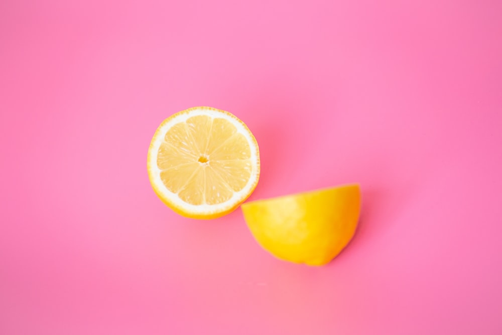 sliced lemon on pink surface