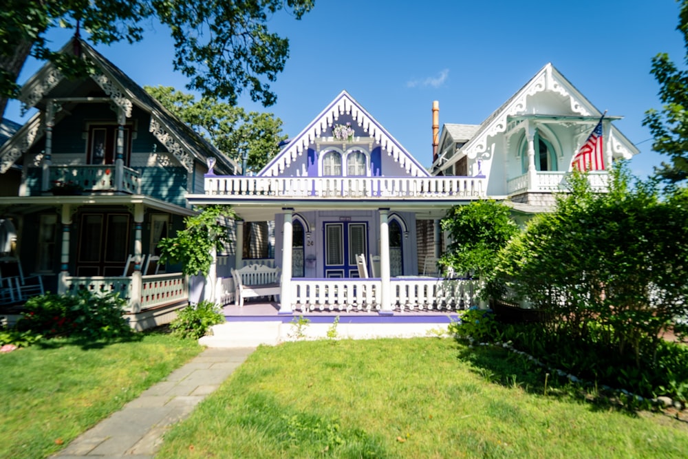 white and black wooden house near green trees under blue sky during daytime