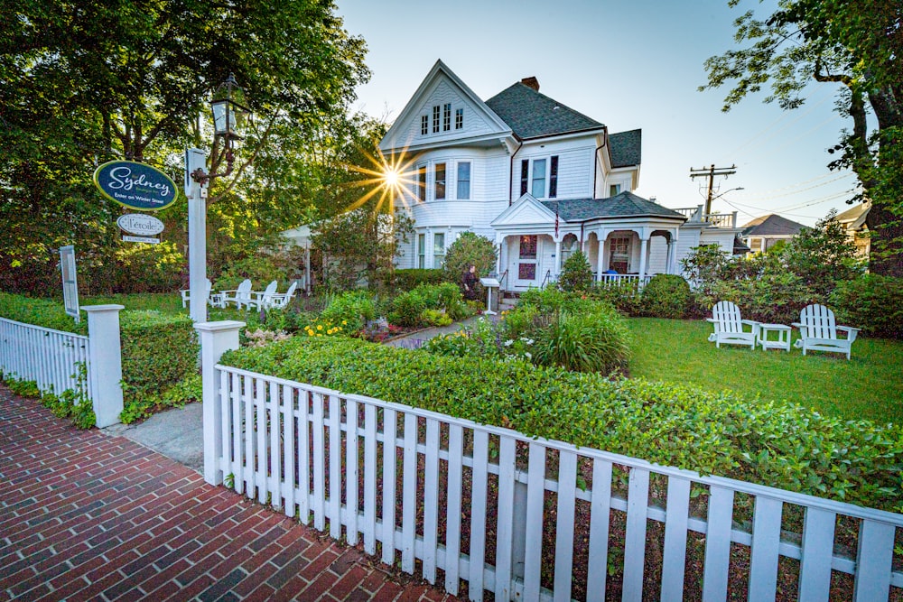 white wooden fence near white and brown house