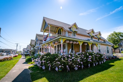 A peaceful homestead featuring a wraparound porch and blooming flower beds.