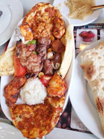 An inviting platter of mixed grilled meats including chicken and köfte with char marks.